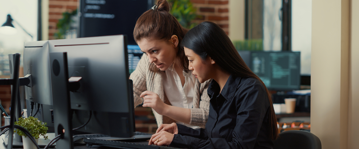 2 girls coding on screen